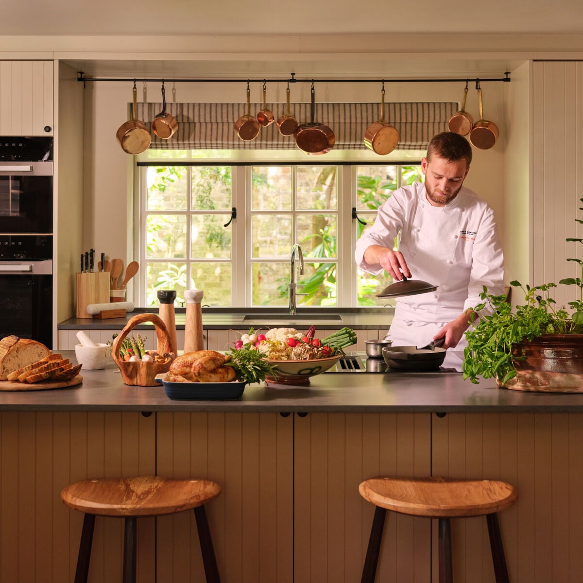 Chef preparing a meal in the country kitchen at Coworth Park, Ascot