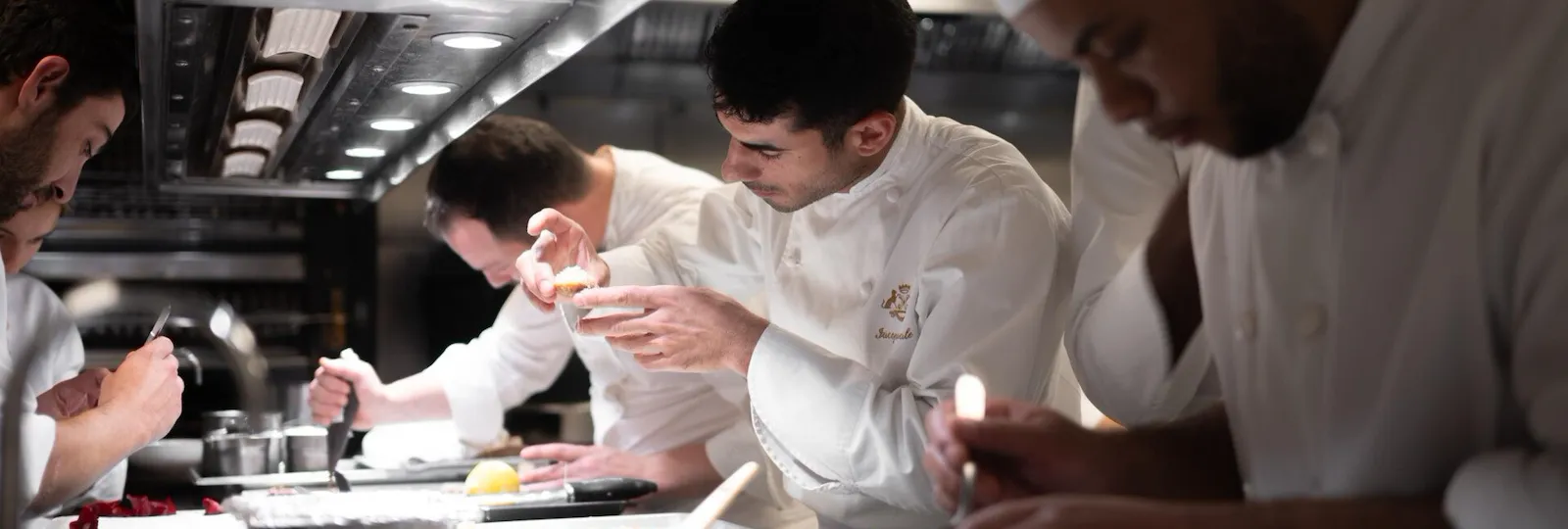 It is a photo of chefs very focused on the dressage of their plates in the kitchen, at Le Meurice, Paris.