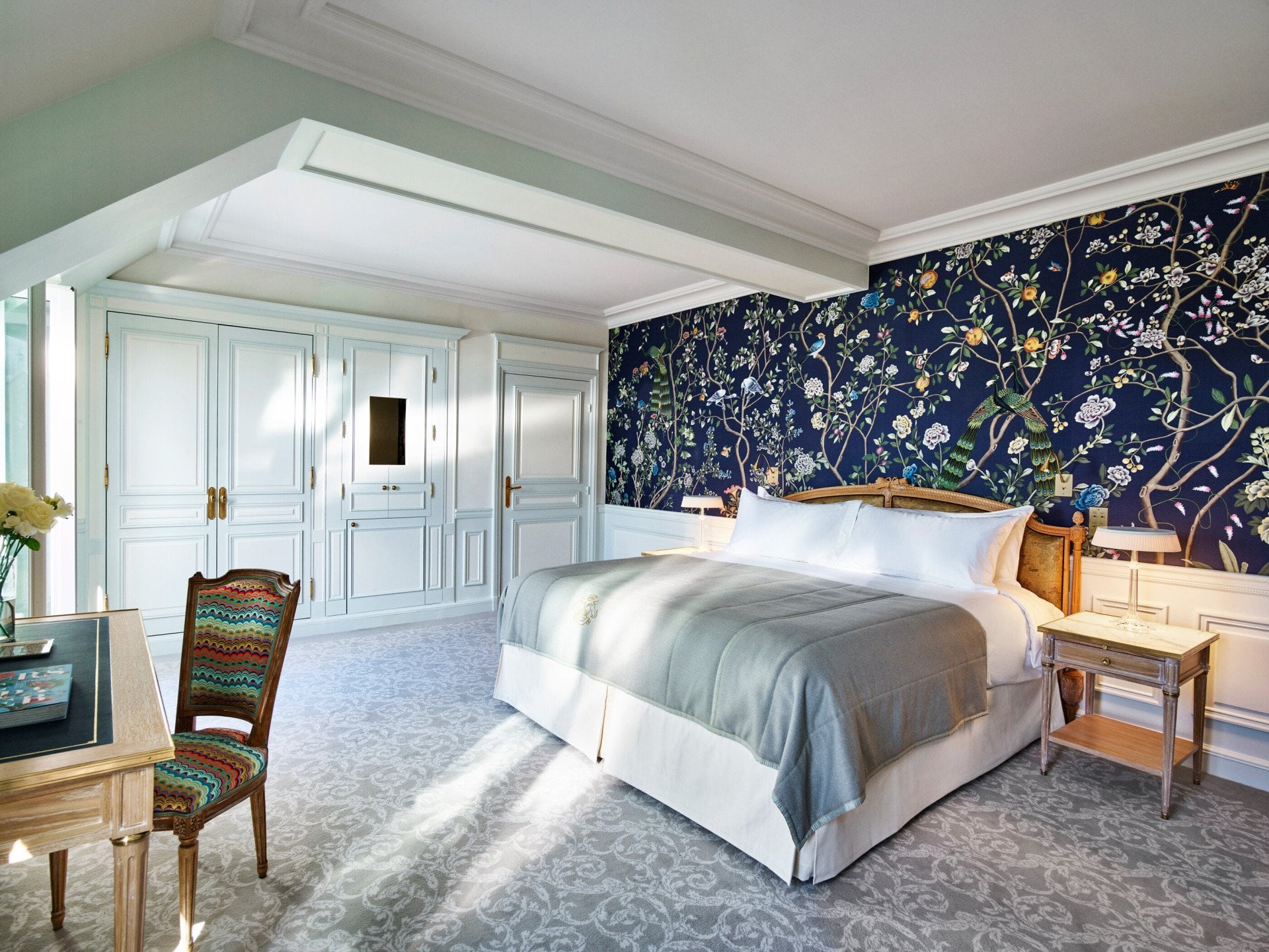 Overview of an executive room with balcony highlighting the dark blue hand painted wall with nature details. At Le Meurice, Paris.