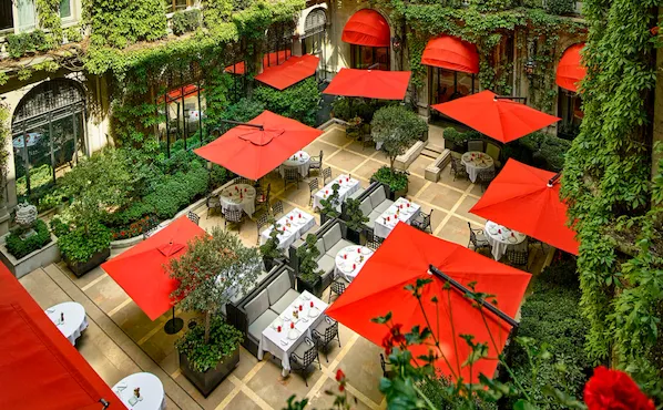 La Cour Jardin Courtyard green vine, red awnings and parasols seen from above, at Hotel Plaza Athénée, Paris