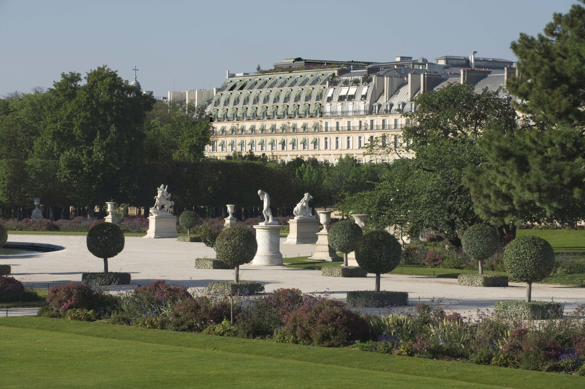 Distant view of the hotel from the Tuileries Garden point of view, showing the top part of the façade and the green shades, at the Tuileries Gardens, Paris.