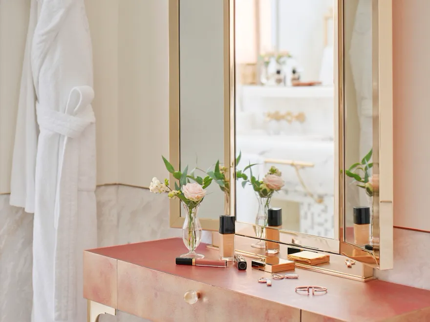 Vanity table with makeup products and bathrobe inside bathroom of Prestige suite at Hotel Eden, Rome