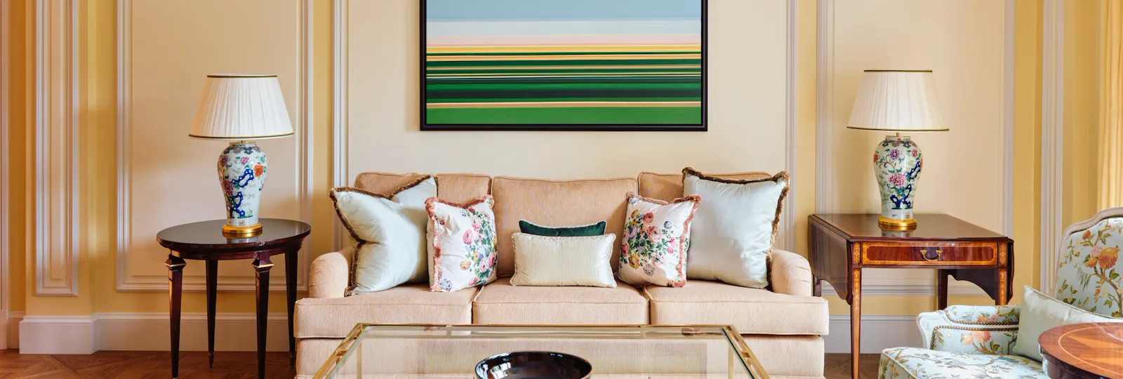 A timeless room with an attractive sofa flanked by floral lamps on elegant tables