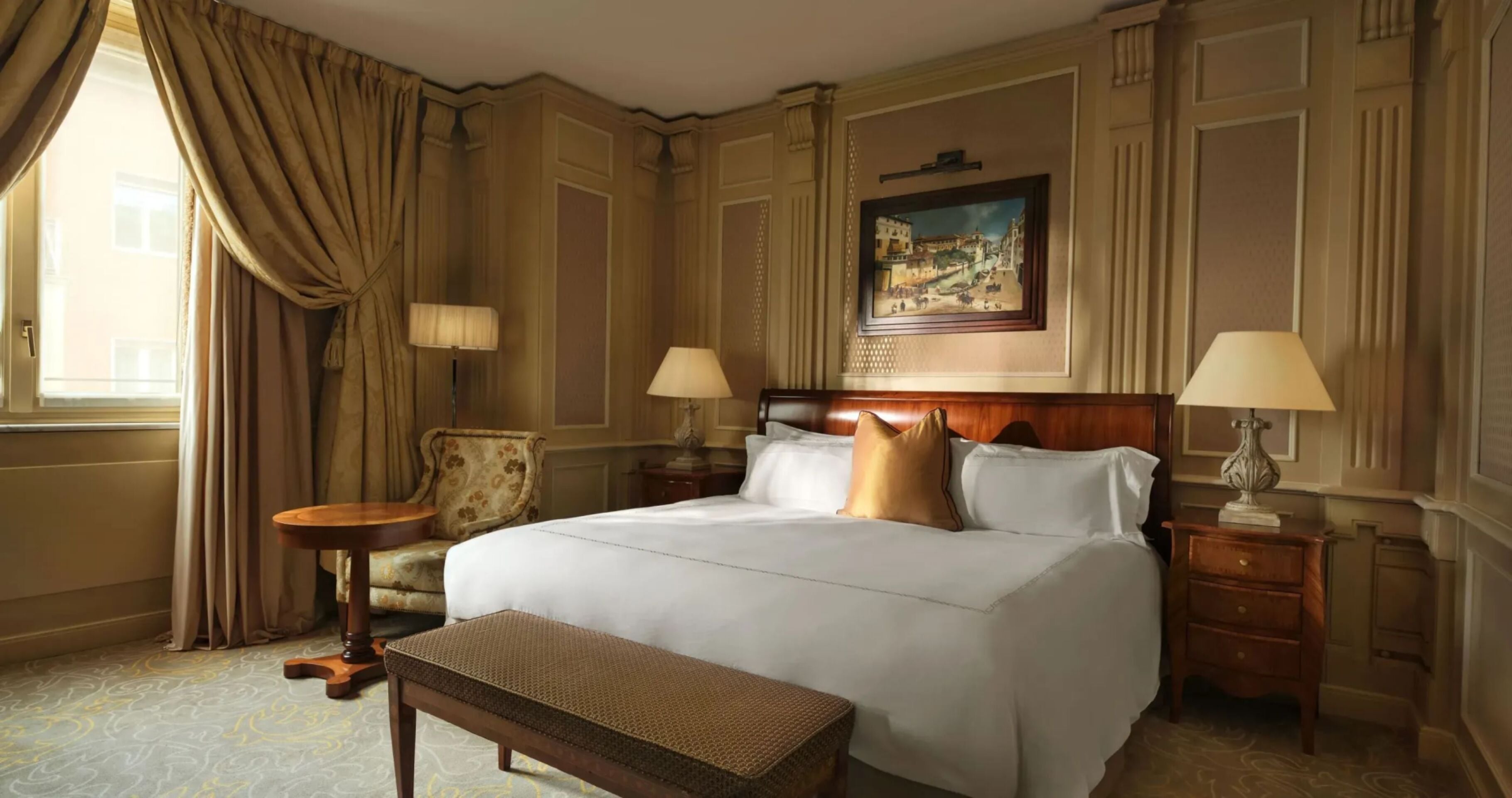Classic room with soft cream and gold colors, wood details and bedside lamps