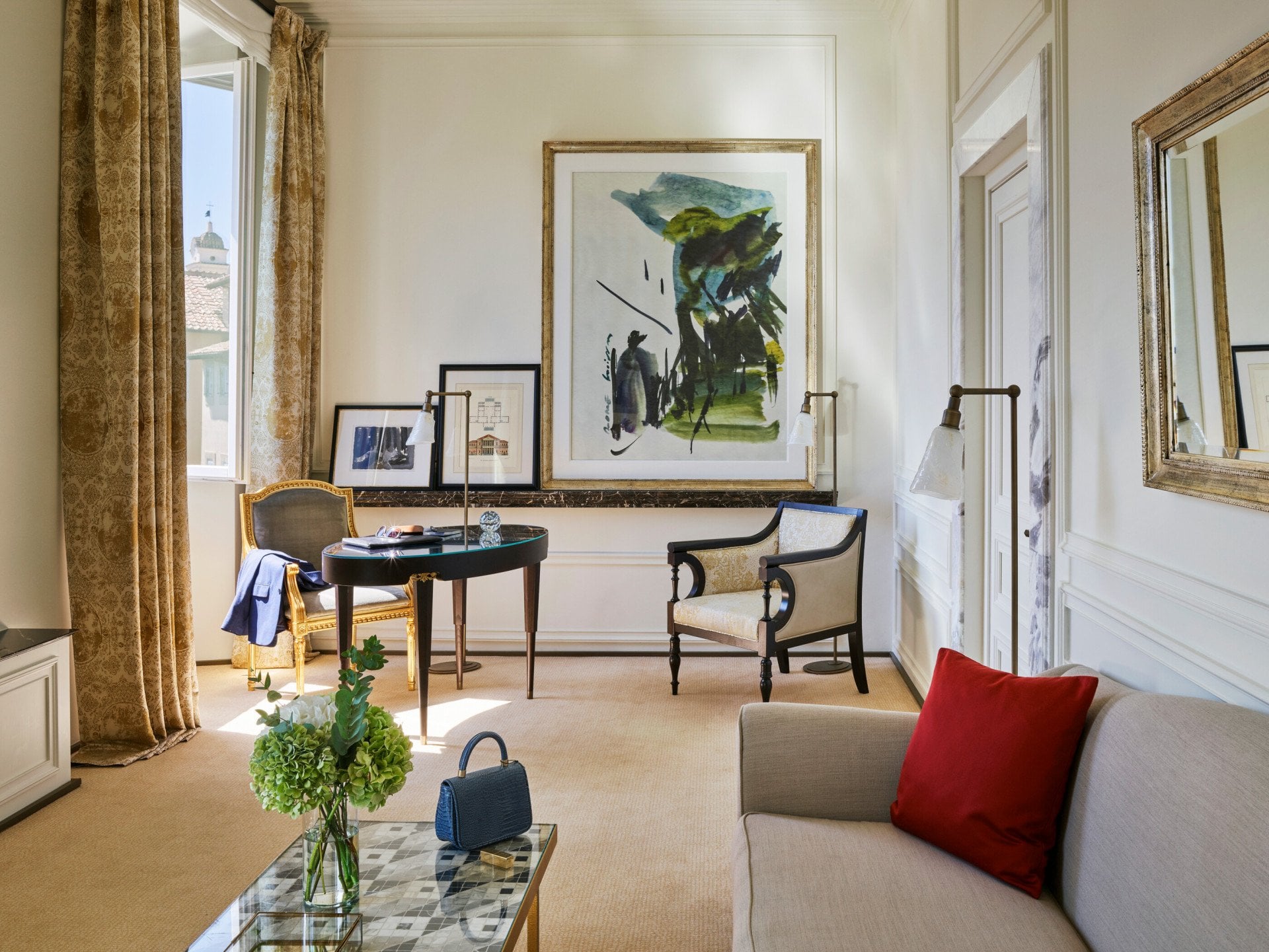 Living room of Prestige suite with sofa, desk, armchair, paintings and view of Rome at Hotel Eden